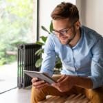 Mies istuu ja katsoo iPadilta EmCen kirjanpito- ja palkanlaskentaohjelman hintaa.
