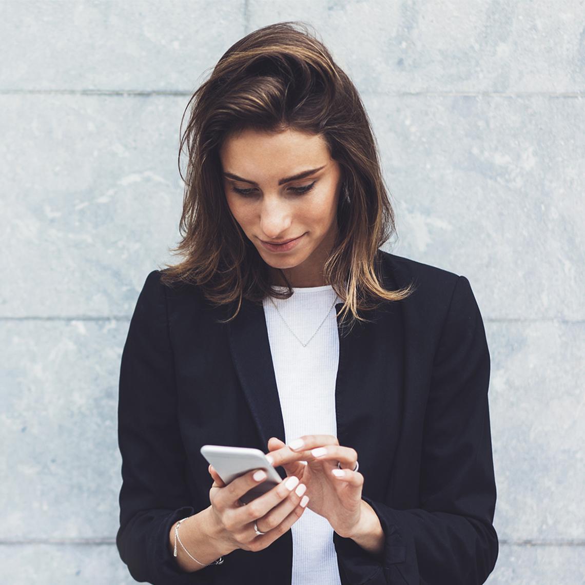 Tyttö katsoo kännykältä EmCen sähköistä palkkalaskelmaa